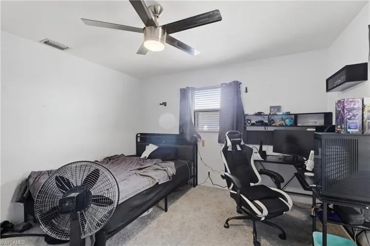 Carpeted flooring, ceiling fan with integrated lighting, and a window with blinds