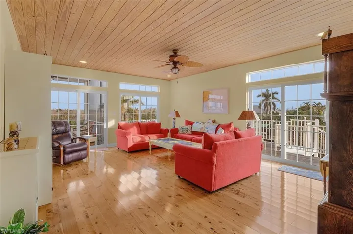 The living room has two open decks with sliders and additional sliding glass doors to a screened porch.  The floors are cypress and the ceiling is pine for a warm coastal feeling.