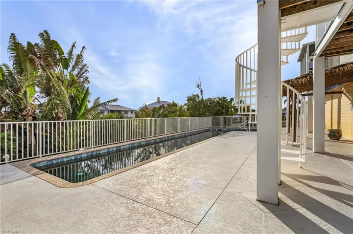 Large pool deck, circular stairs to living room, and a tiki overhang to relax out of the sun!