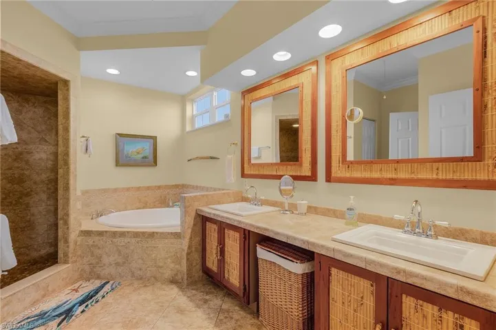The primary bath has dual sinks and a separate tub and shower.  The water closet is separate.  In the hallway between the bedroom and the bathroom are his and her closets.