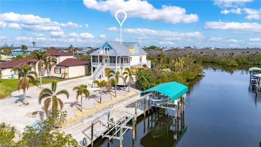 Aerial of the 100+/- feet of dock and seawall with covered 20K# boat lift and additional 7K# boat lift.