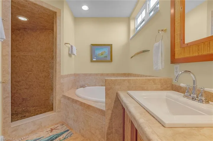 The primary bath has a walk-in shower, a separate tub, and dual sinks.