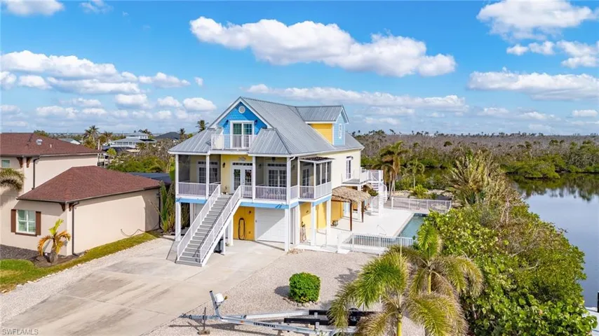 Aerial of this three-story tropical home on an oversized with private back bay views.
