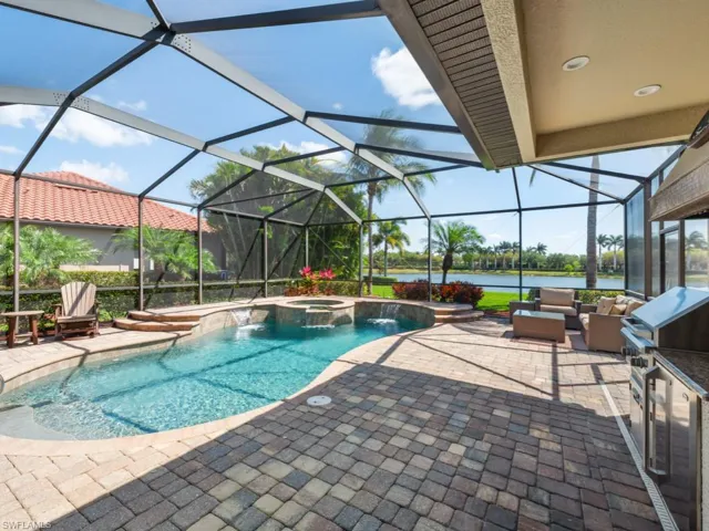 View of swimming pool featuring an outdoor hangout area, a patio area, a water view, glass enclosure, and a pool with connected hot tub