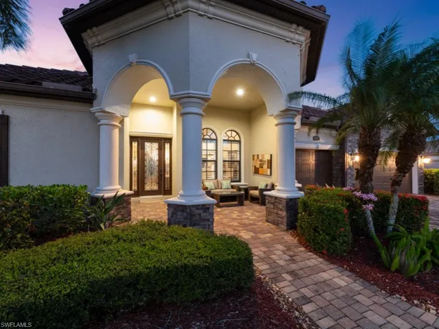 View of exterior entry with stucco siding, covered porch, an attached garage, and a tile roof