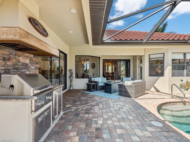 View of patio / terrace with an outdoor kitchen, an outdoor hangout area, glass enclosure, area for grilling, and an outdoor pool