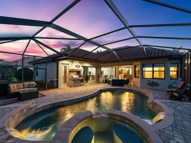 View of pool with a pool with connected hot tub, a patio area, outdoor lounge area, and an outdoor kitchen