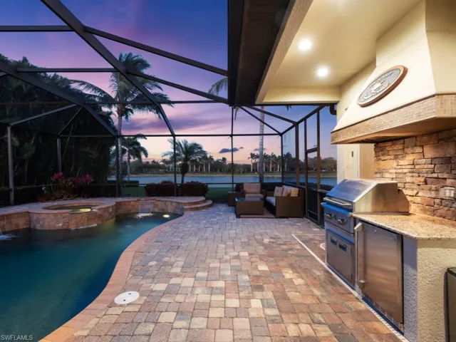 View of patio with a water view, an outdoor hangout area, area for grilling, a pool with connected hot tub, and exterior kitchen