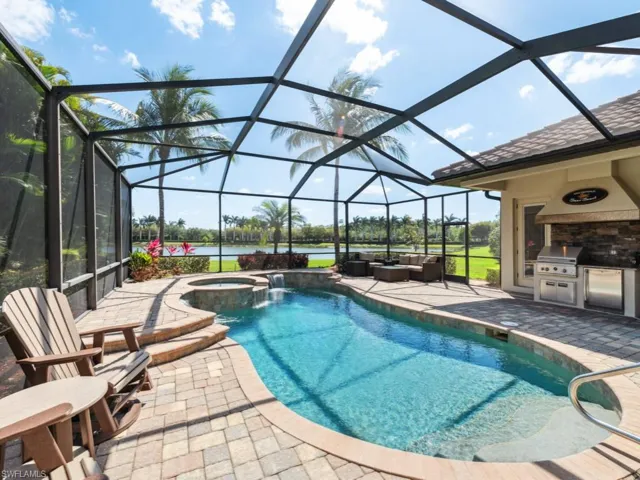 View of pool featuring a patio, a grill, outdoor lounge area, area for grilling, and glass enclosure