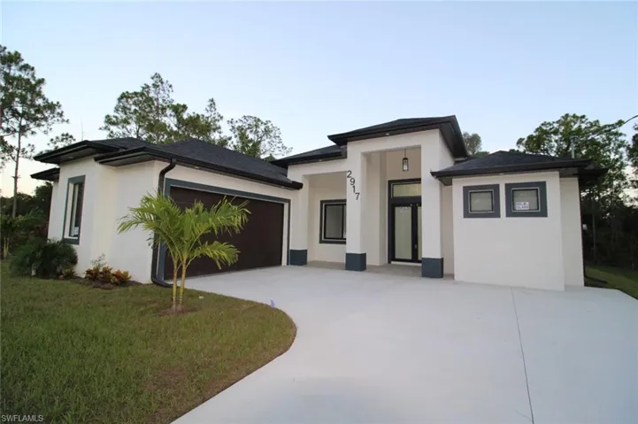 Prairie-style house featuring a garage and a front lawn