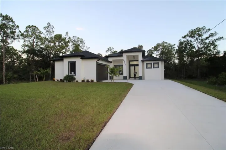 Prairie-style house featuring a garage and a front yard