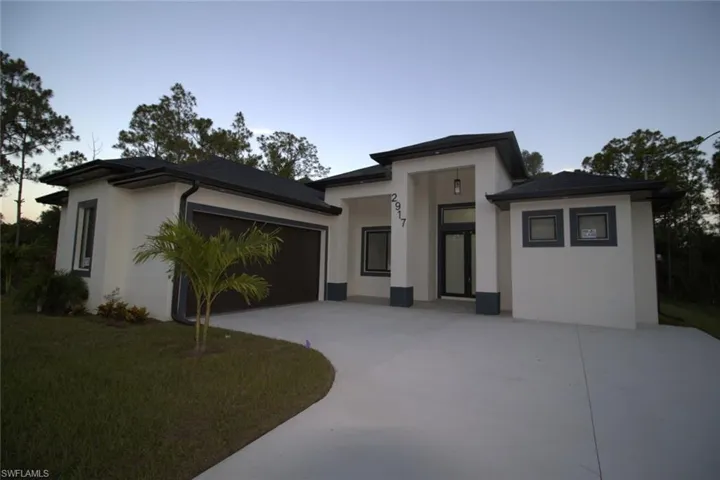Prairie-style house featuring a garage and a lawn