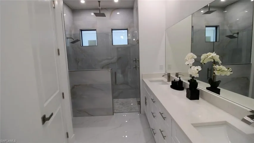 Bathroom featuring vanity and a shower with door