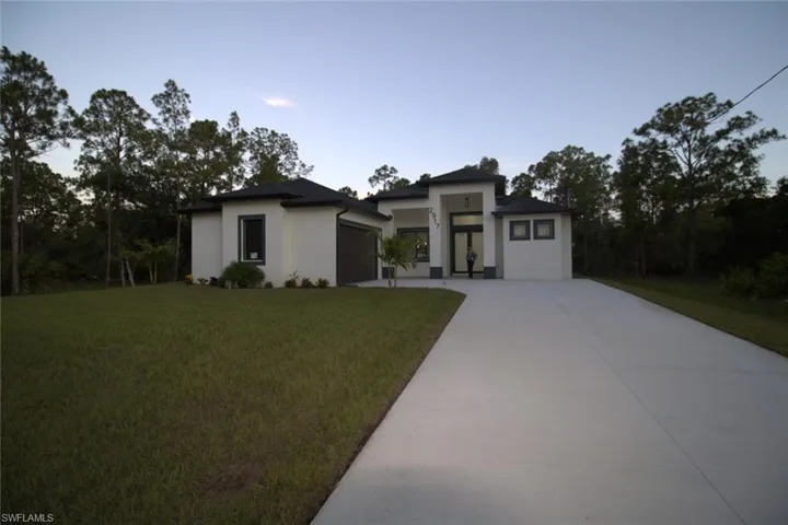 View of front of house featuring a garage and a front lawn