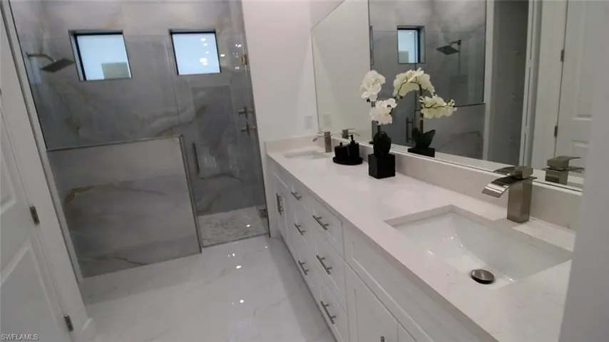 Bathroom featuring vanity and a shower with door