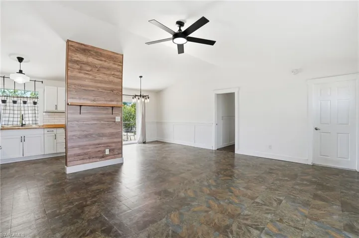 Open-concept living space featuring vaulted ceilings, a contemporary ceiling fan, and tile flooring