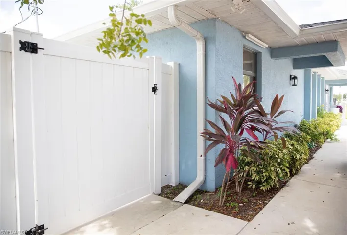 View of side of home with a gate and stucco siding