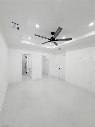 Unfurnished bedroom featuring a spacious closet, recessed lighting, connected bathroom, ceiling fan, and finished concrete flooring