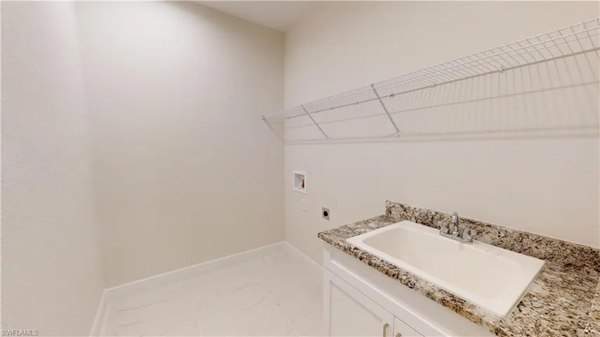 Laundry room featuring washer hookup, sink, electric dryer hookup, and cabinets