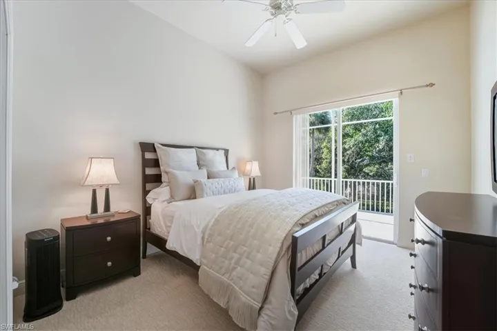 Carpeted bedroom featuring access to exterior and a ceiling fan