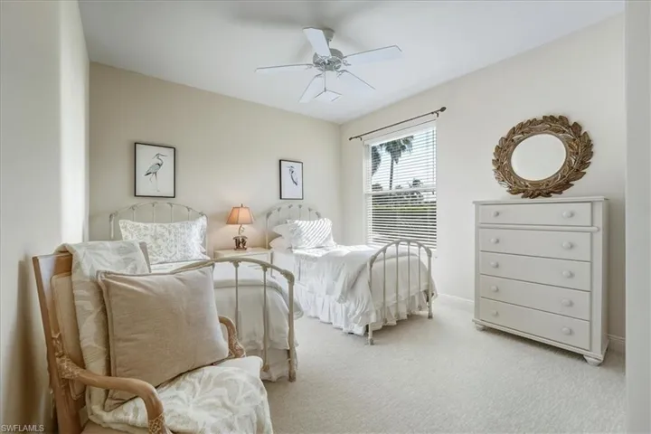 Carpeted bedroom featuring ceiling fan and baseboards