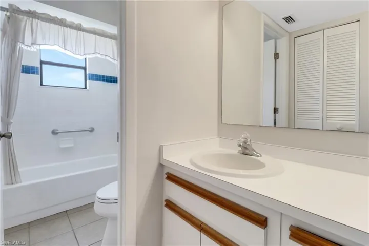 Full bath with shower / bath combo, visible vents, toilet, vanity, and tile patterned floors