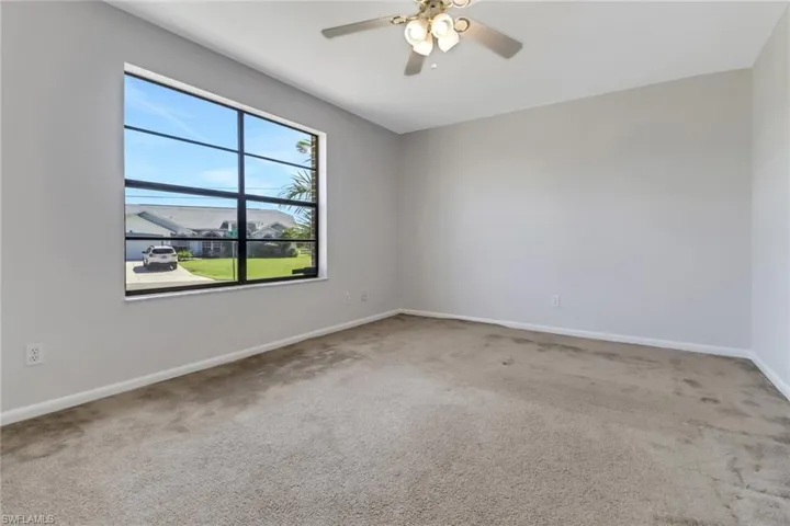 Unfurnished room featuring baseboards, a ceiling fan, and carpet