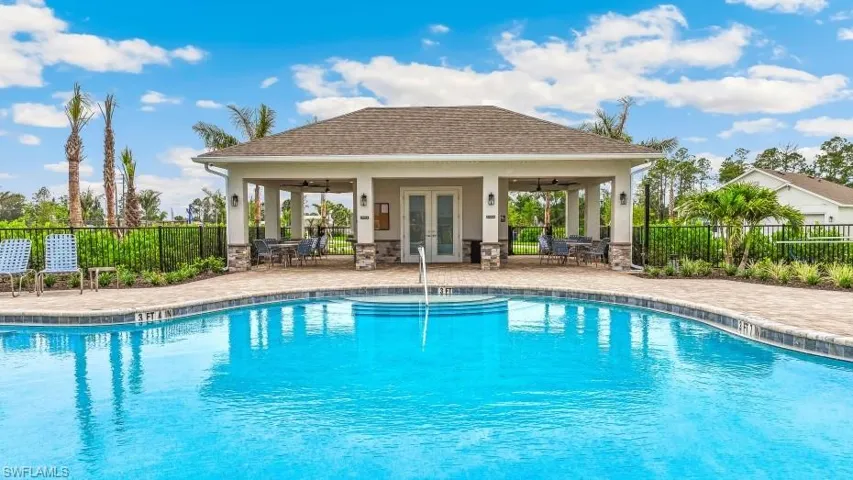Shimmering swimming pool with integrated steps, surrounded by paver decking