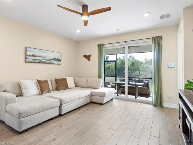 Living room with ceiling fan and light hardwood / wood-style flooring