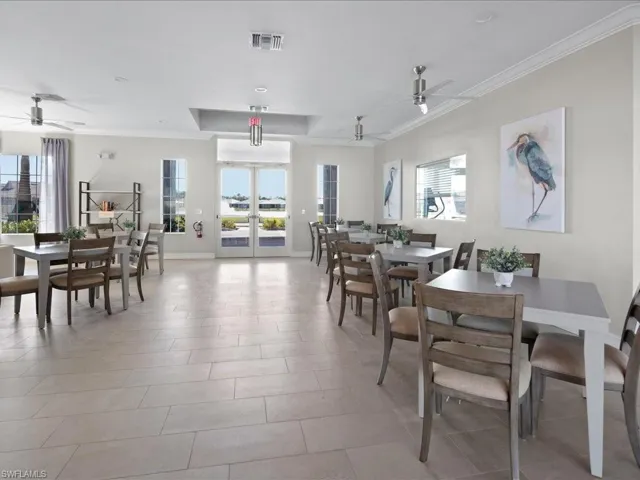 Tiled dining area featuring a wealth of natural light, french doors, and crown molding