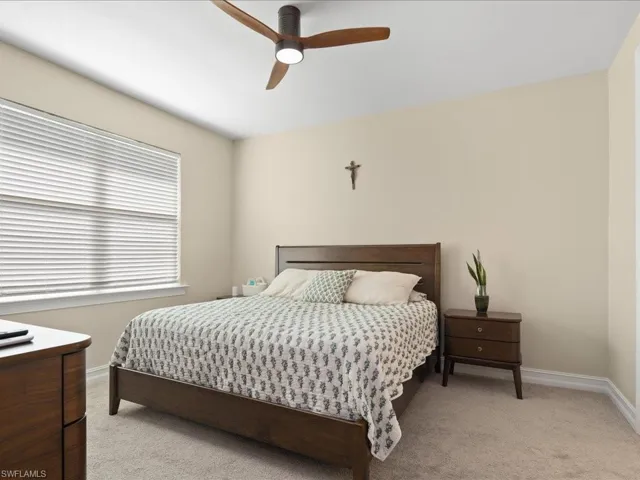 Carpeted bedroom featuring ceiling fan