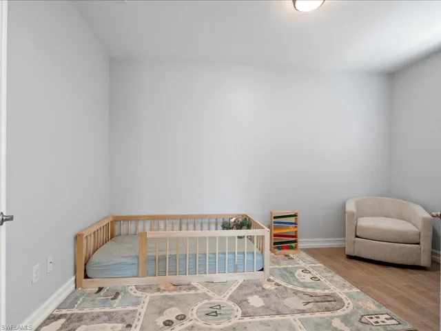 Bedroom with hardwood / wood-style flooring
