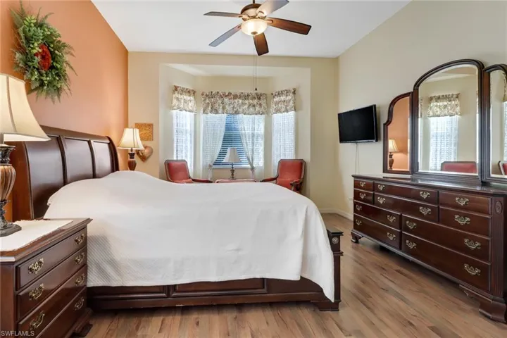 Bedroom with hardwood / wood-style flooring, ceiling fan, and multiple windows