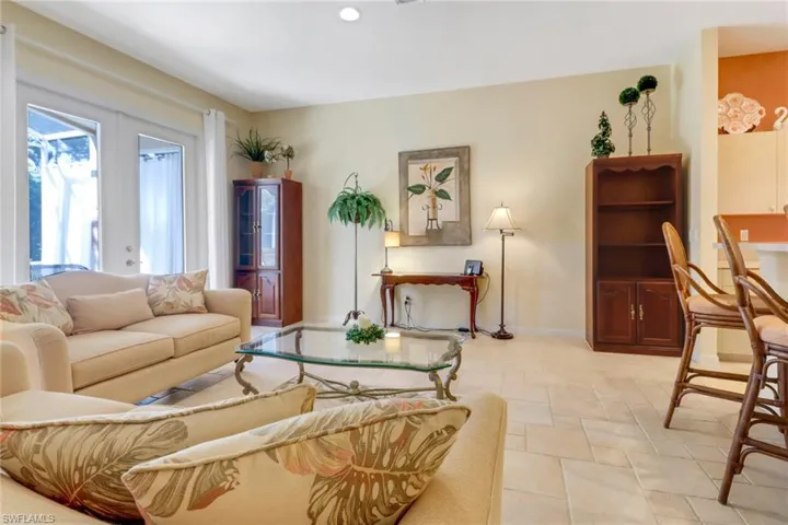 Tiled living room featuring french doors