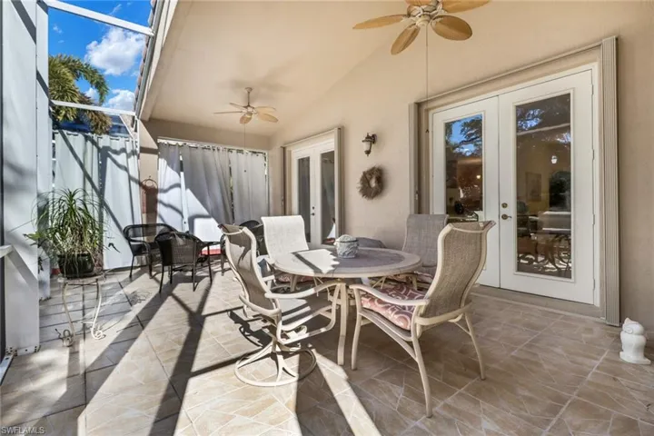 View of patio featuring french doors, glass enclosure, and ceiling fan
