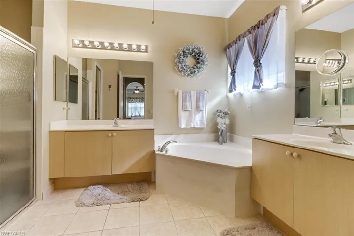 Bathroom featuring tile patterned flooring, vanity, and plus walk in shower