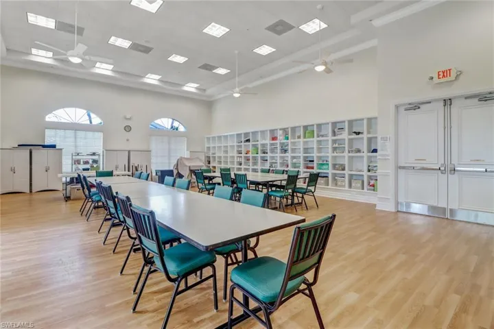 Dining area with ceiling fan, a high ceiling, and light hardwood / wood-style flooring