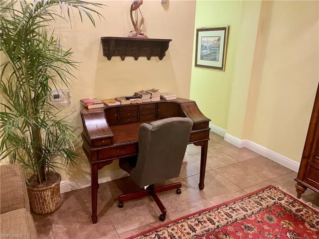 Office area featuring light tile patterned floors and baseboards