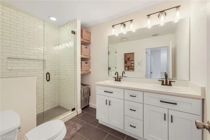 Ensuite primary bathroom features shaker cabinets, dual sinks and a walk-in shower.