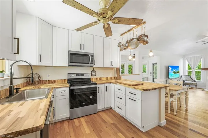 Main home boats open concept kitchen featuring stainless appliances, shaker cabinets and wood counter tops.