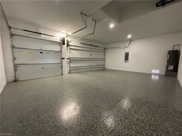 Spacious garage with an epoxy finished floor, two garage doors, and overhead lighting