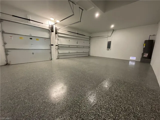 This expansive garage features two overhead doors, a textured floor, and recessed lighting