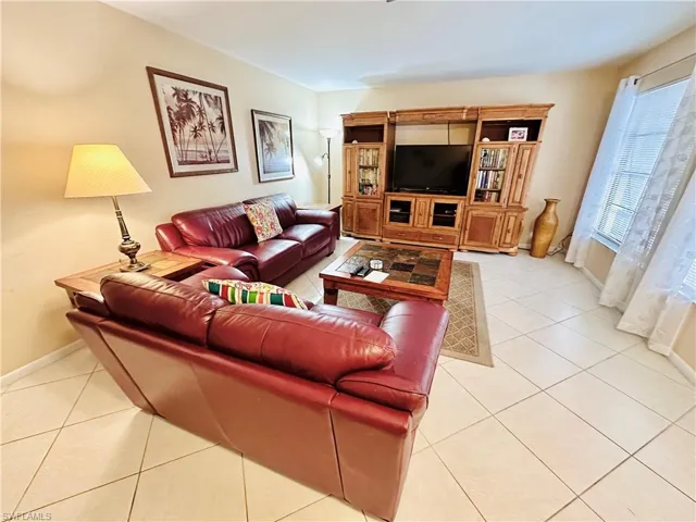 Living area featuring light tile patterned flooring and baseboards