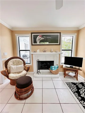 Tiled living room featuring ornamental molding and a tile fireplace