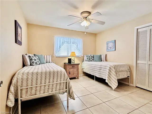 Tiled bedroom with a closet and a ceiling fan