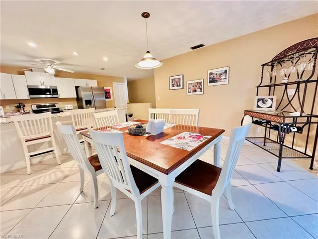 Dining area featuring light tile patterned floors, recessed lighting, and a ceiling fan