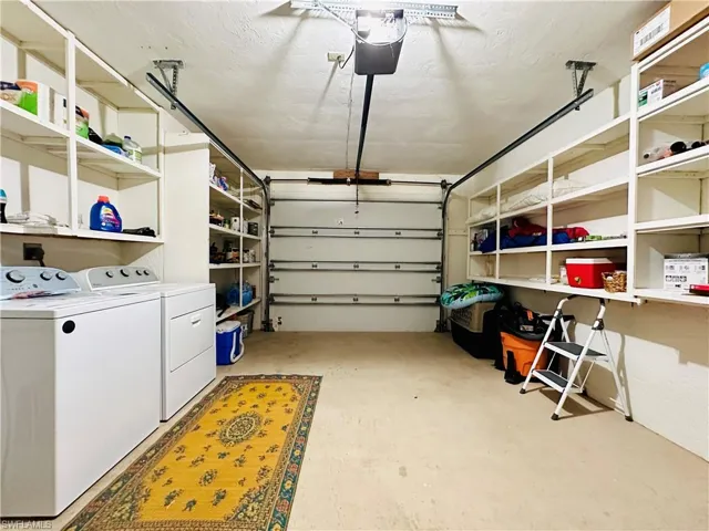 Garage featuring separate washer and dryer and a garage door opener
