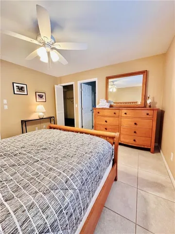 Bedroom with light tile patterned floors and ceiling fan