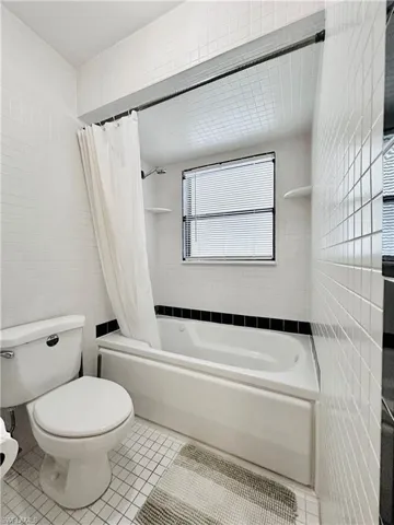 Bathroom with tile walls, tile patterned flooring, and shower / tub combo
