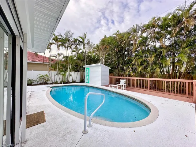 View of pool featuring a patio, a fenced backyard, and a storage shed
